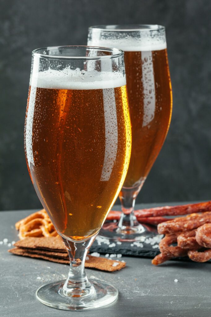 beer and appetizing beer snacks set. Table with mug of beer, wooden board with sausages