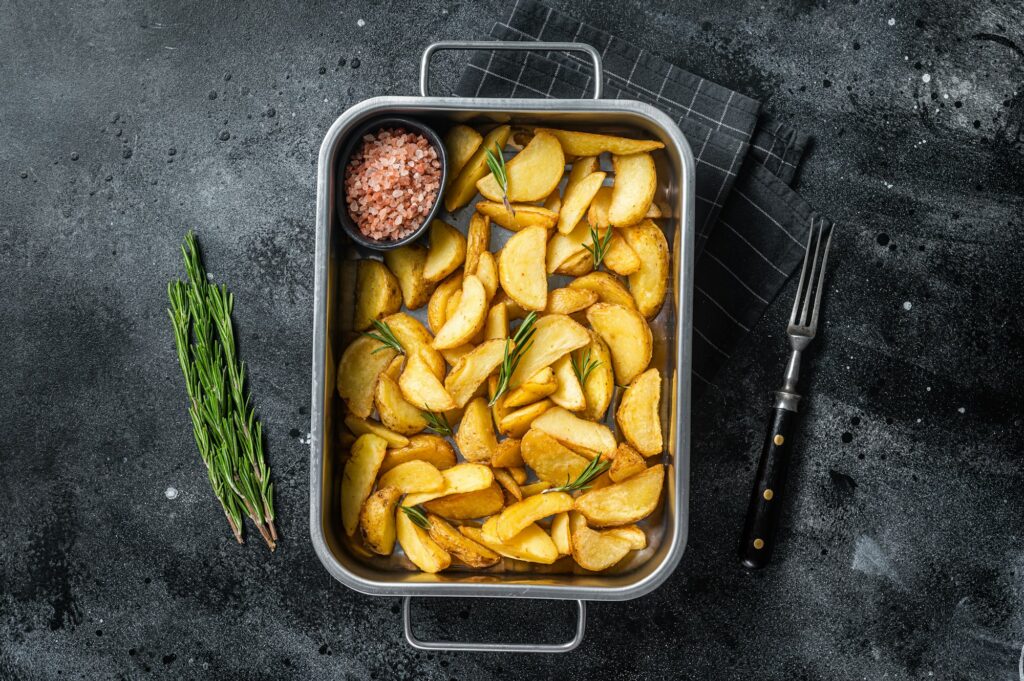 Oven Baked potato wedges with herbs, homemade organic vegan vegetarian potato wedges snack.